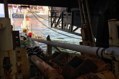 Pijpleiding die over de rollenbaan van een legschip de zee in gaat